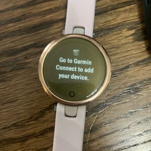 Garmin Lily Smartwatch - Rose Gold with Light Tan Case and multiple color bands.